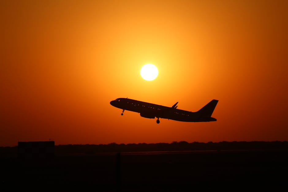 Airplane taking off against a vibrant sunset sky